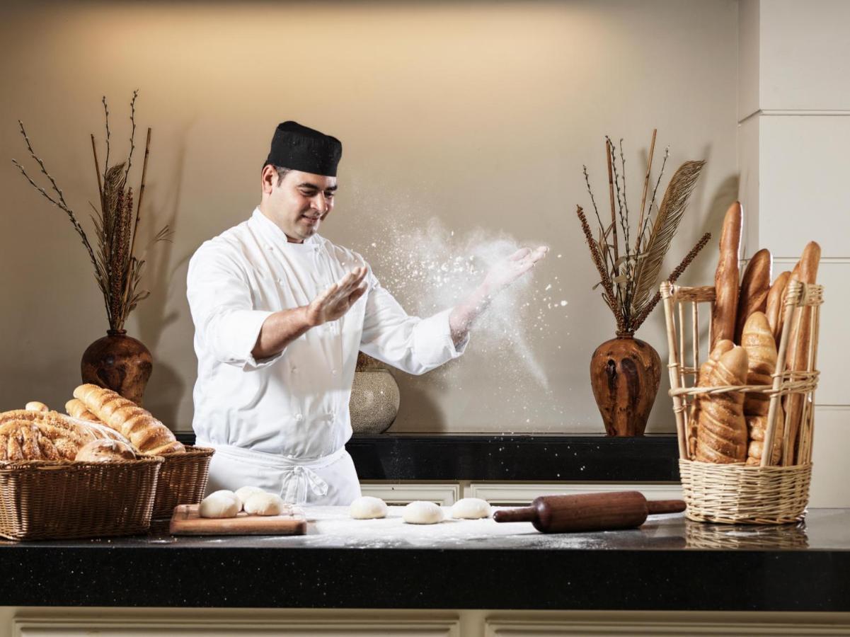 アル ファナル ホテル アンド レジデンシズ サラーラ エクステリア 写真 A baker preparing bread